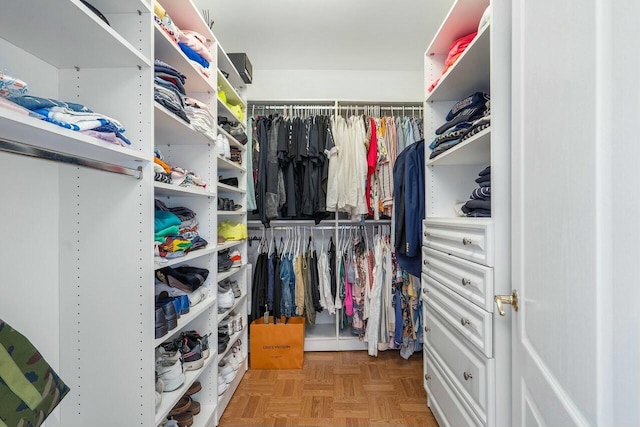 walk in closet with light parquet flooring