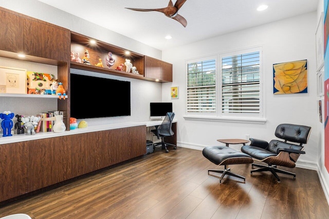 home office featuring dark wood-type flooring, built in desk, and ceiling fan