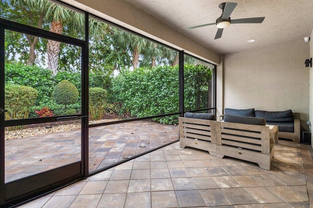 unfurnished sunroom with ceiling fan