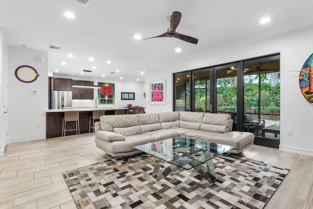 living room featuring ceiling fan and sink