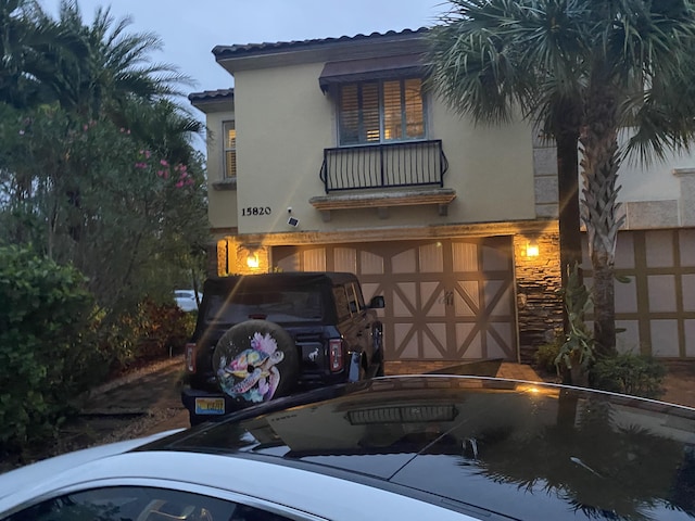 view of front of property featuring a balcony and a garage