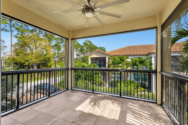 unfurnished sunroom featuring ceiling fan