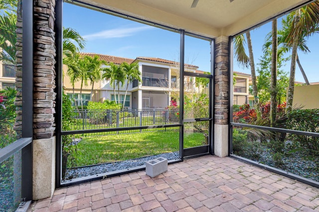 unfurnished sunroom with ceiling fan