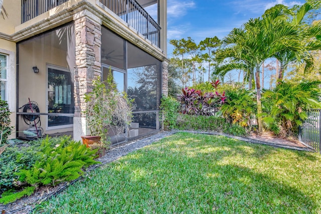 view of yard with a balcony and a sunroom