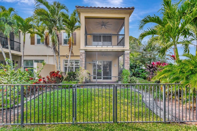 back of property featuring a balcony, a yard, and ceiling fan