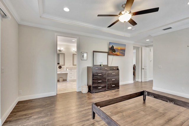 bedroom featuring hardwood / wood-style flooring, a raised ceiling, and ornamental molding