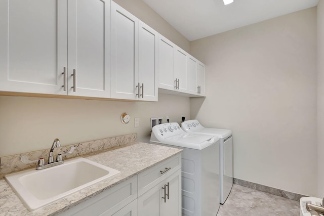 laundry room with cabinets, washer and dryer, sink, and light tile patterned floors