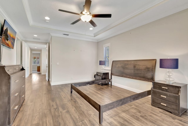 sitting room with a raised ceiling, ornamental molding, and light hardwood / wood-style floors