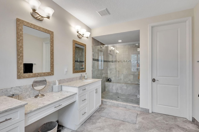 bathroom with vanity, a textured ceiling, and walk in shower