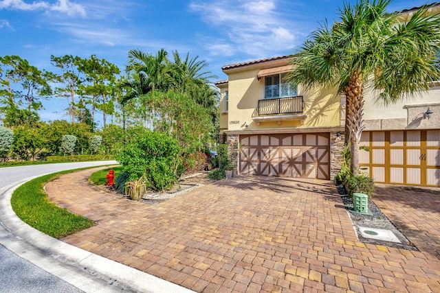 view of front of property featuring a garage and a balcony