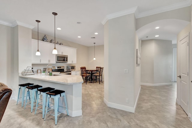 kitchen featuring white cabinets, hanging light fixtures, ornamental molding, kitchen peninsula, and stainless steel appliances