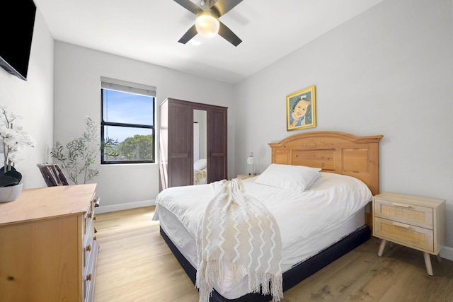 bedroom featuring light wood-type flooring, baseboards, and ceiling fan