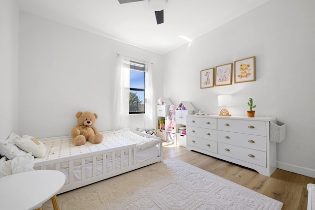 bedroom with ceiling fan, baseboards, and light wood-style flooring