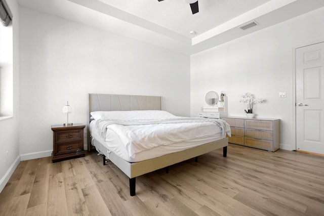 bedroom with baseboards, visible vents, light wood finished floors, and ceiling fan