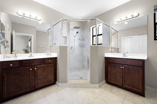 full bath with a sink, two vanities, and a stall shower