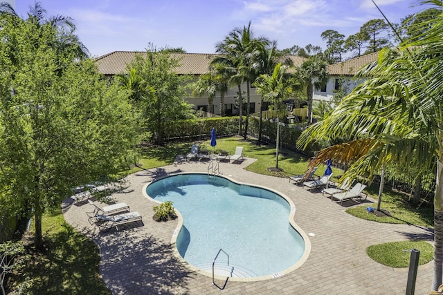 community pool with a patio, a yard, and a fenced backyard