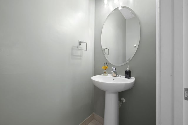 bathroom featuring baseboards and a sink