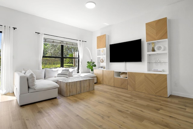 living area featuring light wood finished floors and baseboards