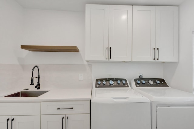 washroom with separate washer and dryer, sink, and cabinets