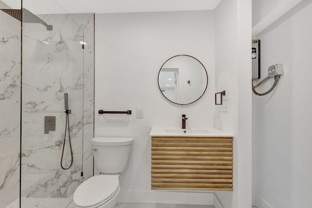 bathroom featuring vanity, tiled shower, and toilet