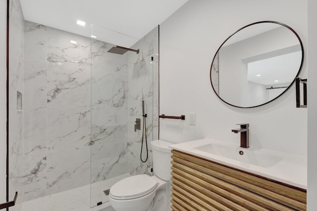 bathroom with vanity, tiled shower, and toilet