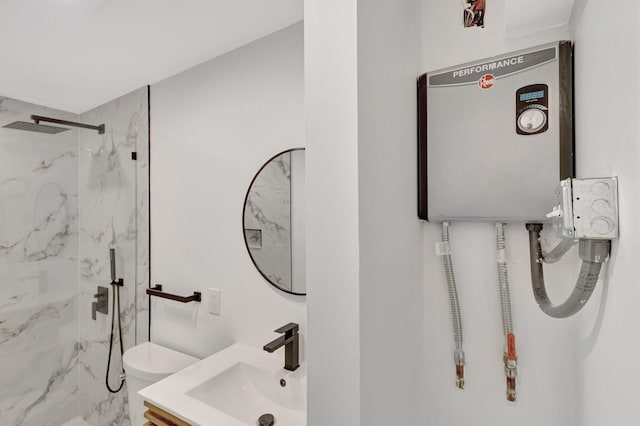 bathroom featuring tiled shower, vanity, and toilet