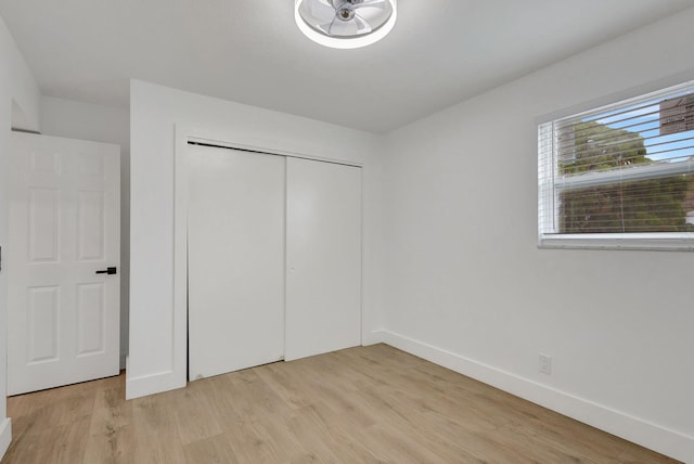 unfurnished bedroom with a closet and light wood-type flooring