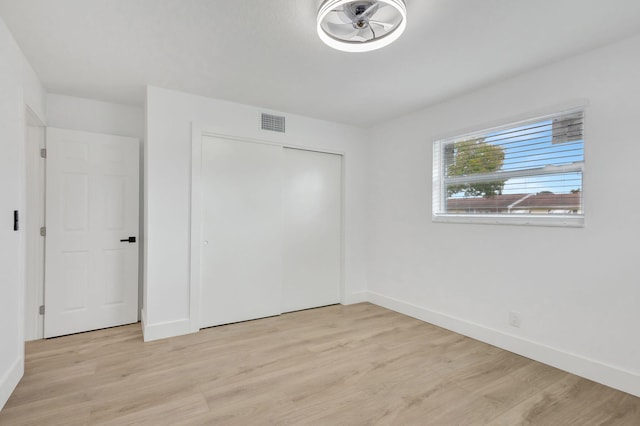 unfurnished bedroom with a closet and light hardwood / wood-style flooring