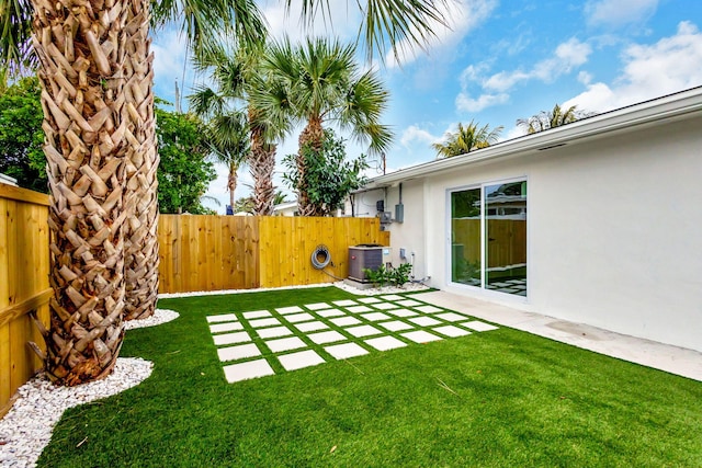 view of yard with central AC and a patio area