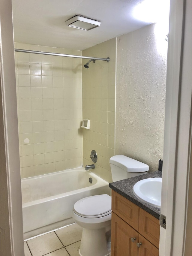 full bathroom with toilet, vanity, tiled shower / bath, and tile patterned flooring