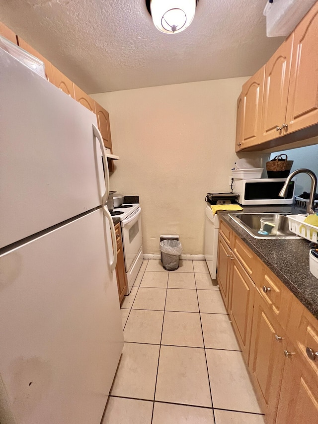 kitchen featuring light tile patterned floors, white appliances, light brown cabinetry, a textured ceiling, and sink