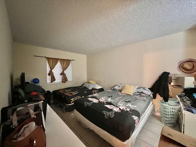 bedroom with a textured ceiling and light tile patterned floors