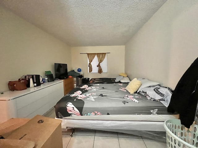 bedroom featuring a textured ceiling and tile patterned floors