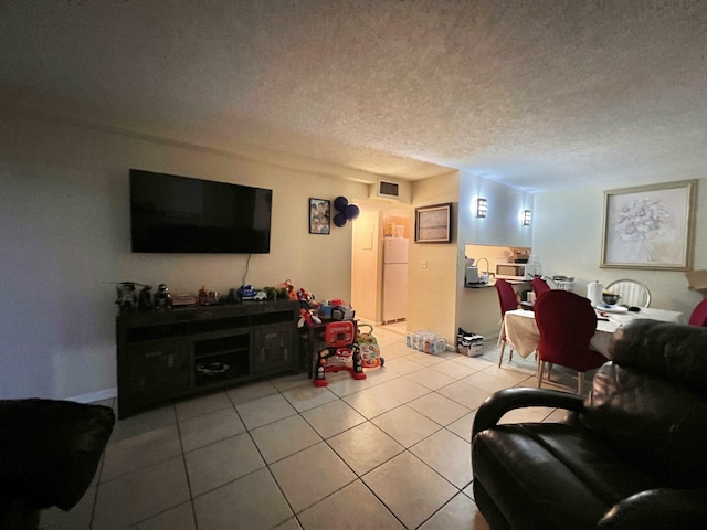 living room with a textured ceiling and light tile patterned floors