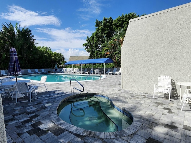 view of pool featuring a hot tub and a patio