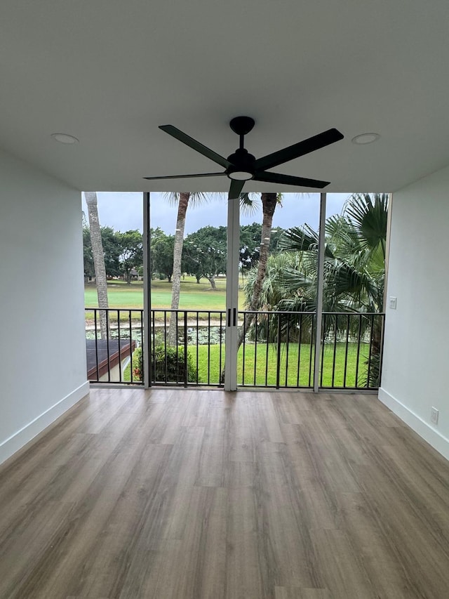 unfurnished sunroom featuring ceiling fan