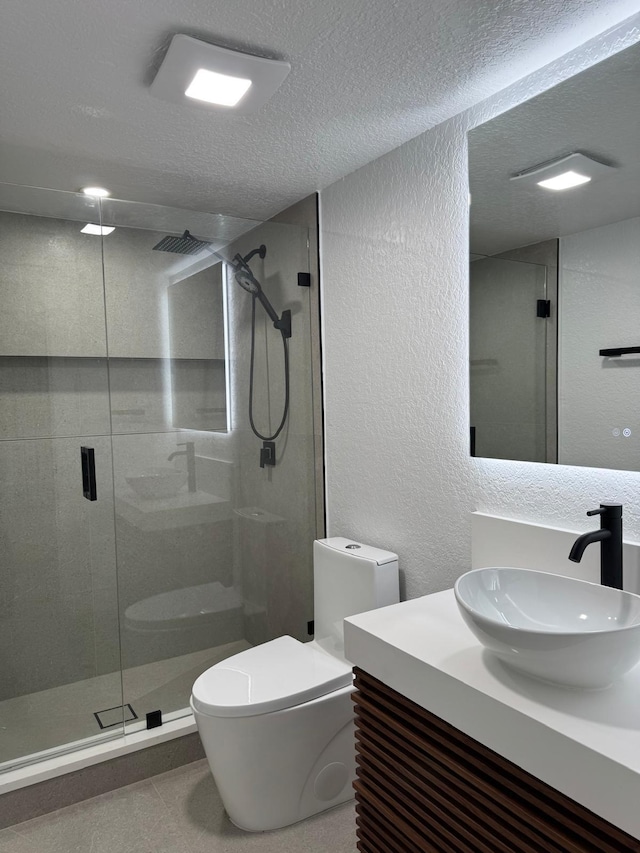 bathroom with toilet, a shower with shower door, tile patterned floors, a textured ceiling, and vanity