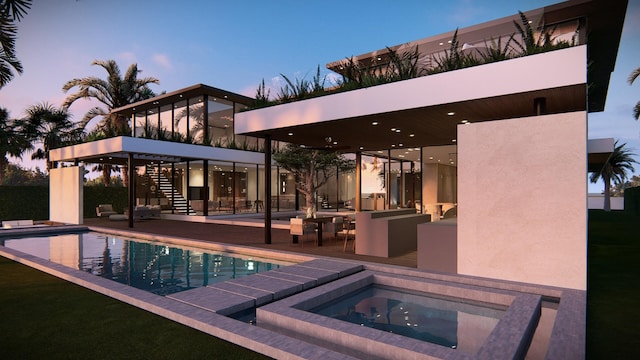 back house at dusk with a swimming pool with hot tub and a patio