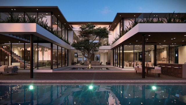 pool at dusk featuring a jacuzzi and exterior bar