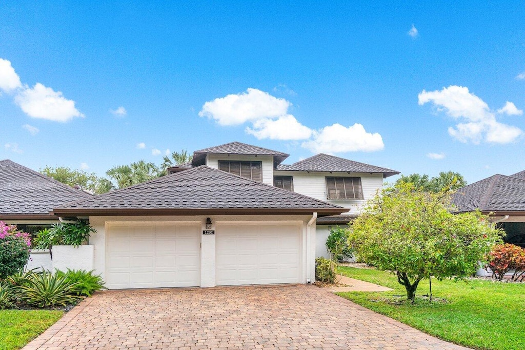 view of front of property featuring a front yard and a garage