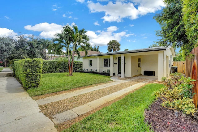 ranch-style house featuring a front lawn and a carport