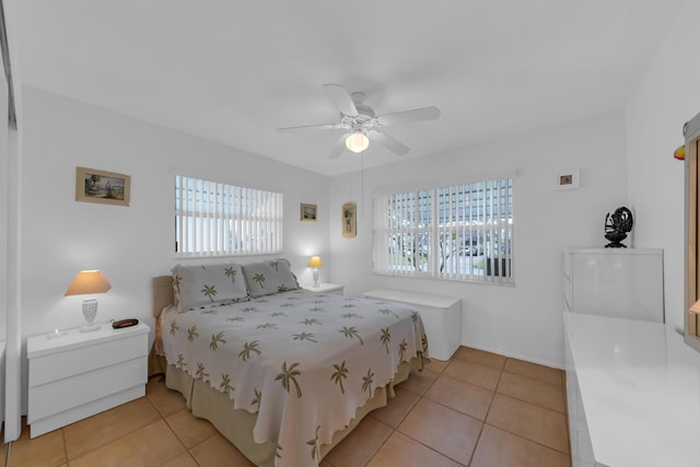 tiled bedroom featuring ceiling fan and multiple windows