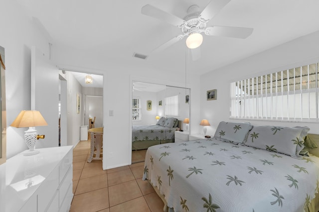 tiled bedroom featuring ceiling fan and a closet