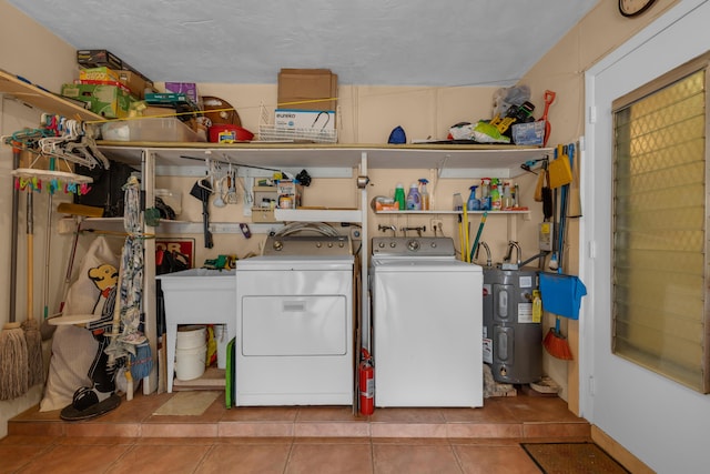 clothes washing area with light tile patterned floors, water heater, and independent washer and dryer