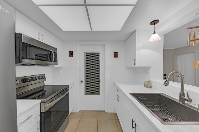 kitchen featuring sink, decorative light fixtures, white cabinets, and appliances with stainless steel finishes