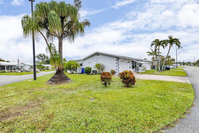 view of front of property with a carport, a front lawn, and central air condition unit