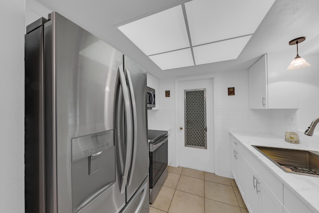 kitchen featuring stainless steel appliances, decorative light fixtures, sink, and white cabinets