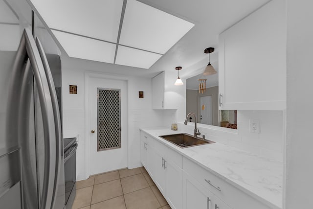 kitchen featuring appliances with stainless steel finishes, sink, white cabinets, and decorative light fixtures