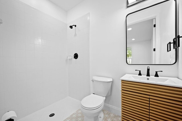 bathroom with vanity, toilet, tile patterned floors, and a tile shower