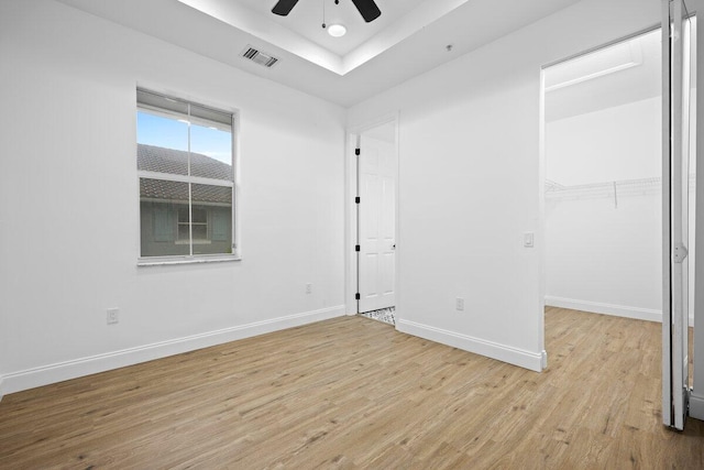 unfurnished bedroom with light wood-type flooring, ceiling fan, and a closet